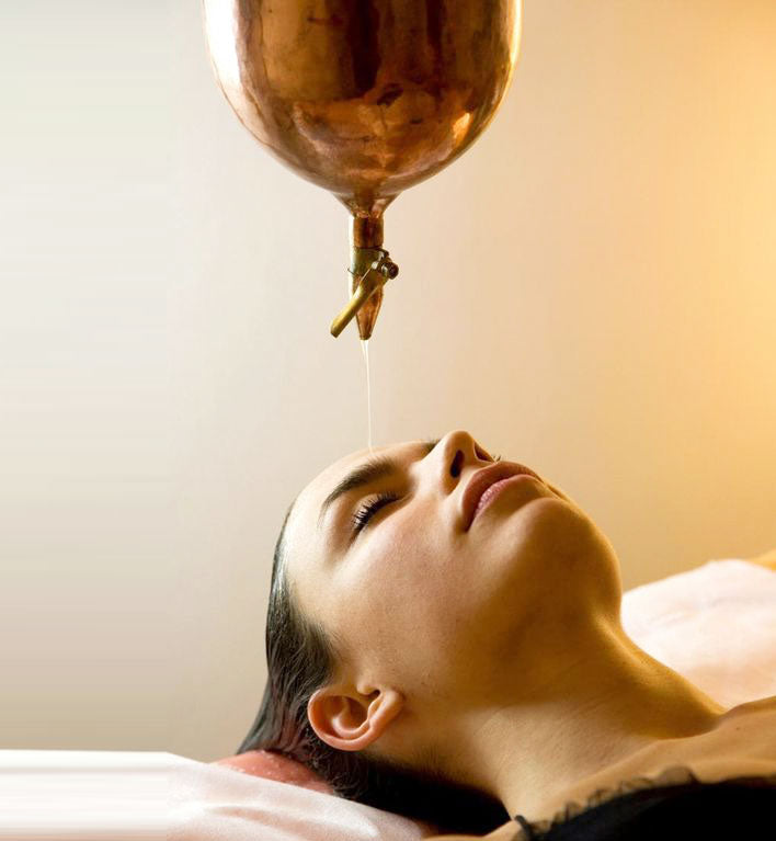 Woman getting Ayurvedic head oil massage Shirodhara for a whole body wellness experience 